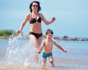 woman and child playing in water