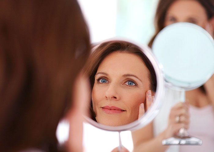 Reflection of woman's face after Microneedling in Boston